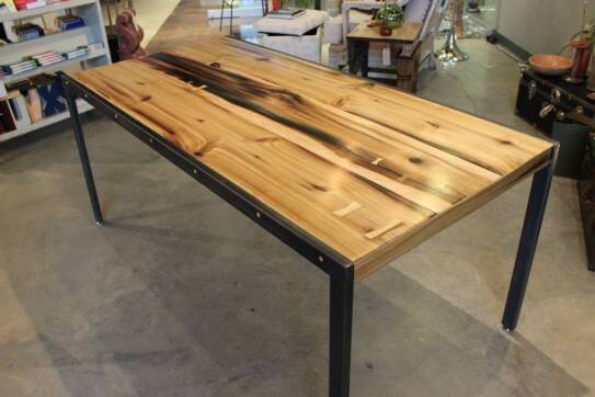 Dining room table made from poplar wood with butterfly splines supported by dark grey metal legs.