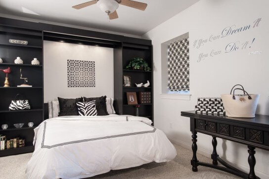 The bookcases dual as a Murphy bed functioning as a guest room by night.